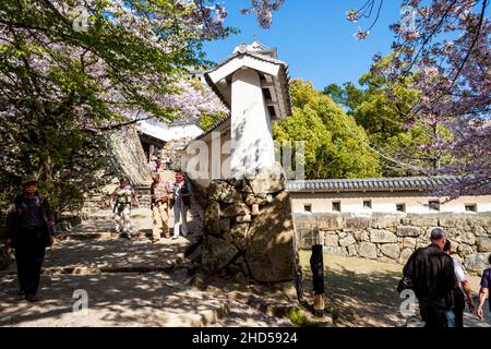 Die berühmte abgestufte Haarnadelkurve mit verteidigender weißer Gipswand beim Anflug auf eines der Ha-Tore auf das berühmte Himeji-Schloss in Japan Stockfoto