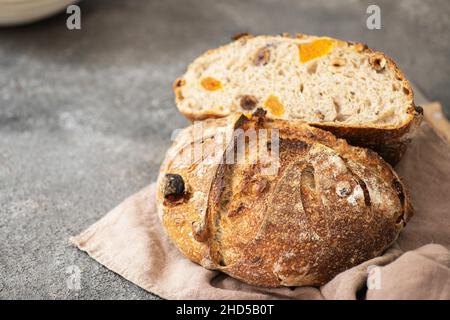 Halbierte Sauerteig Dessertbrot mit getrockneten Aprikosen und Walnüssen auf einer Serviette. Nahaufnahme. Stockfoto