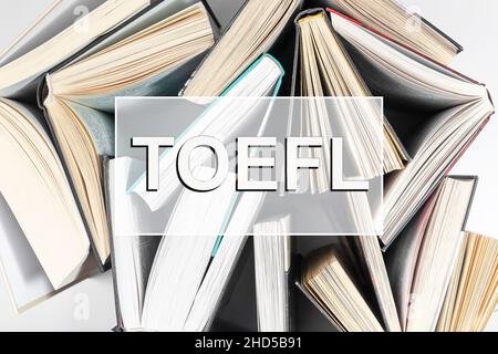 TOEFL-Wort. Testkonzept in englischer Sprache mit Büchern. Stockfoto