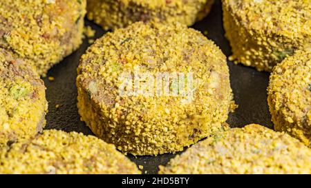 Gefrorene vegetarische Nuggets mit Linsen und Grünpflanzen, Makro Stockfoto