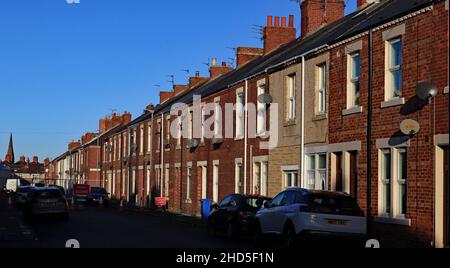 Die starke Wintersonne am Nachmittag hebt die Fenster und Türen auf der William Street in Blyth Blyth ist eine Küstenstadt im Nordosten Englands Stockfoto