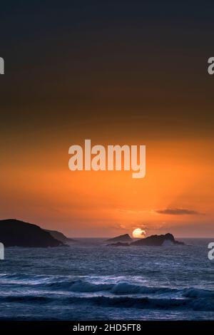 Ein intensiver spektakulärer Sonnenuntergang über der Fistral Bay in Newquay in Cornwall. Stockfoto