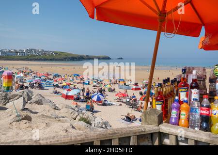 Urlauber entspannen sich in der Sonne am Fistral Beach in Newquay in Cornwall. Stockfoto