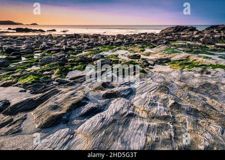 Felsen und Felsenpools bei Ebbe am abgeschiedenen Little Fistral in Newquay in Cornwall. Stockfoto