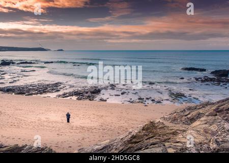 Ein Mann, der allein am Strand von Little Fistral in Newquay in Cornwall steht. Stockfoto