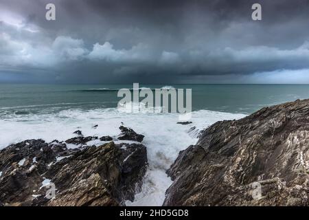 Ein Wellengebäude über den Cribber Rocks vor der Küste von Towan Head in Newquay in Cornwall. Stockfoto