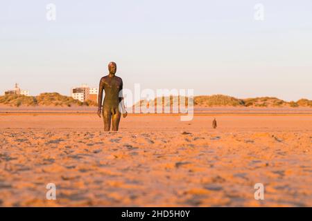 Zwei der hundert Iron Men Statuen am Strand von Crosby in der Nähe von Liverpool, die einen anderen Platz bilden. Stockfoto