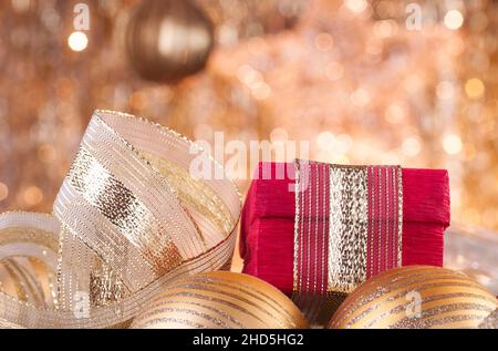 Weihnachtskugeln Gold und rote Feld Hintergrund defokussierten golden Leuchten. Stockfoto