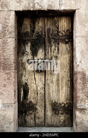 Handgeschmiedete eiserne Türscharniere für antike Holztüren mit dekorativen Schlössern in San Miguel de Allende, Mexiko Stockfoto