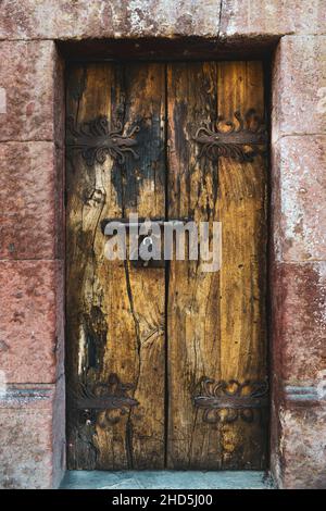 Handgeschmiedete eiserne Türscharniere für antike Holztüren mit dekorativen Schlössern in San Miguel de Allende, Mexiko Stockfoto