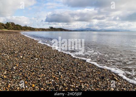 Am Strand von Llanbedrog werden Wellen hochgeschlappen. Stockfoto