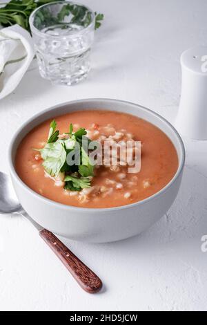 Gerstensuppe in Keramikschale auf weißem Tisch, vegane Ernährung auf pflanzlicher Basis, Nahaufnahme Stockfoto