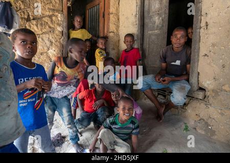 Pemba Island, Sansibar, Tansania - Januar 2020 : Junge fröhliche afrikanische Kinder in einem abgelegenen Dorf in der Nähe ihres einfachen Armenheims. Stockfoto