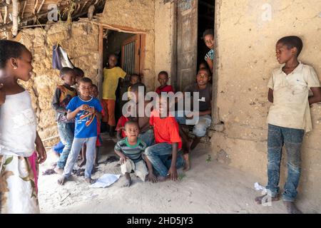 Pemba Island, Sansibar, Tansania - Januar 2020 : Junge fröhliche afrikanische Kinder in einem abgelegenen Dorf in der Nähe ihres einfachen Armenheims. Stockfoto