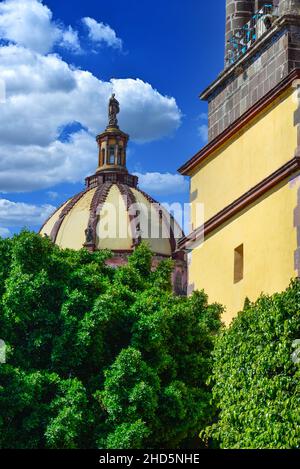 Die Kuppel erhebt sich über den Baumwipfeln zusammen mit dem Glockenturm des Klosters der Unbefleckten Empfängnis in San Miguel de Allende, Mexiko Stockfoto