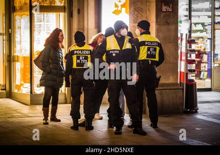 München, Bayern, Deutschland. 3rd Januar 2022. Beim Versuch, die Polizei zu umgehen, begannen bekannte Coronarebels, darunter eine Gruppe von „Resurfacing Junge Alternative/Identitaere Bewegung/Burschenschaften“ unter der Leitung von David S., ihre Spaziergänge in der Fußgängerzone von München. Trotz Tricks wie dem Vorgeben, als ob sie beim Einkaufen wären, komplett mit Taschen von lokalen Unternehmen, kennt die Polizei die Taktik und die Stammgäste und zerbricht Gruppen, die nicht den Corona-Vorschriften entsprechen. (Bild: © Sachelle Babbar/ZUMA Press Wire) Stockfoto