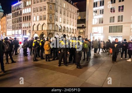 München, Bayern, Deutschland. 3rd Januar 2022. Beim Versuch, die Polizei zu umgehen, begannen bekannte Coronarebels, darunter eine Gruppe von „Resurfacing Junge Alternative/Identitaere Bewegung/Burschenschaften“ unter der Leitung von David S., ihre Spaziergänge in der Fußgängerzone von München. Trotz Tricks wie dem Vorgeben, als ob sie beim Einkaufen wären, komplett mit Taschen von lokalen Unternehmen, kennt die Polizei die Taktik und die Stammgäste und zerbricht Gruppen, die nicht den Corona-Vorschriften entsprechen. (Bild: © Sachelle Babbar/ZUMA Press Wire) Stockfoto