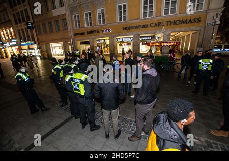 München, Bayern, Deutschland. 3rd Januar 2022. Beim Versuch, die Polizei zu umgehen, begannen bekannte Coronarebels, darunter eine Gruppe von „Resurfacing Junge Alternative/Identitaere Bewegung/Burschenschaften“ unter der Leitung von David S., ihre Spaziergänge in der Fußgängerzone von München. Trotz Tricks wie dem Vorgeben, als ob sie beim Einkaufen wären, komplett mit Taschen von lokalen Unternehmen, kennt die Polizei die Taktik und die Stammgäste und zerbricht Gruppen, die nicht den Corona-Vorschriften entsprechen. (Bild: © Sachelle Babbar/ZUMA Press Wire) Stockfoto