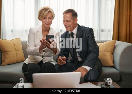 Geschäftsfrau zeigt etwas Geschäftsmann auf dem Smartphone Stockfoto