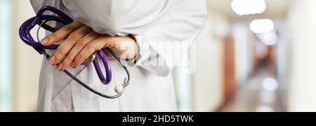 Arzt mit Stethoskop. Auf dem Hintergrund des verschwommenen Krankenhauskorridors. Stockfoto