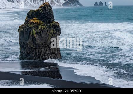 Arnardrangur liegt am Ende des schwarzen Sandstrandes von Reynisfjara Stockfoto