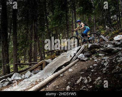 Banff Alberta Kanada, 04 2021. Juli: Ein junges Mädchen fährt mit dem Mountainbike eine steile Felsplatte hinunter Stockfoto