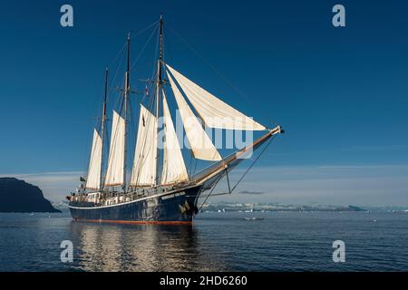 Rembrandt van Rijn unter Segel in Scoresby Sund bei leichter Brise, Jameson Land im Hintergrund, Ostgrönland Stockfoto