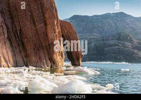 Sandsteinbogen mit Eisschollen, Rode O mit Milne Land in BG, Rodefjord, Scoresby Sund, Grönland Stockfoto