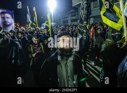 Gaza-Stadt, Palästina. 03rd Januar 2022. Demonstranten des Palästinensischen Islamischen Jihad marschieren mit Fahnen und Transparenten von Hisham Abu Hawasch, 40, der seit mehr als 140 Tagen in Hungerstreik ist, nachdem er von Israel verhaftet und in Verwaltungshaft genommen wurde. Kredit: SOPA Images Limited/Alamy Live Nachrichten Stockfoto