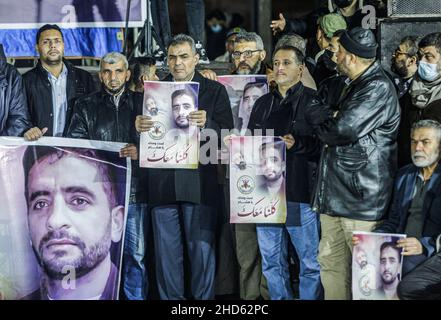 Gaza-Stadt, Palästina. 03rd Januar 2022. Die Demonstranten des Palästinensischen Islamischen Jihad zeigen Bilder von Hisham Abu Hawasch, 40, der sich seit mehr als 140 Tagen in einem Hungerstreik befindet, nachdem er von Israel verhaftet und in Verwaltungshaft genommen wurde. Kredit: SOPA Images Limited/Alamy Live Nachrichten Stockfoto