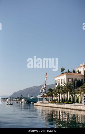 Küste mit grünen Palmen und modernen Luxushäusern des Resorts Porto. Montenegro Stockfoto