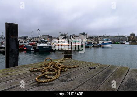 Cherbourg En Cotentin, Frankreich. 24th Dez 2021. Eine Gesamtansicht des handwerklichen Fischerhafens von Cherbourg mit der Stadt im Hintergrund. Die Fischereiindustrie im Hafen von Cherbourg (Manche) bereitet sich auf das erste Jahr der Fischereisaison nach dem Brexit vor. 40 % der fischenden Mengen stammen aus den britischen Gewässern von Jersey und Guernsey, für die die Fischer Lizenzen erhalten haben. (Foto: Laurent Coust/SOPA Images/Sipa USA) Quelle: SIPA USA/Alamy Live News Stockfoto