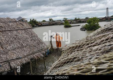 Mongla, Bangladesch. 12th September 2021. Eine Frau steht vor ihrem Haus, das aufgrund eines Wirbelsturms im Küstengebiet des Dorfes Jaymani mehrmals wiederaufgebaut wird.Bangladesch ist eines der Länder, das am stärksten von den Auswirkungen des Klimawandels betroffen ist. Die regelmäßigen und schweren Naturgefahren, die Bangladesch bereits unter tropischen Wirbelstürmen, Hochwasser, Flußerosion, Überschwemmungen, Erdrutschen und Dürren leidet, werden durch den Klimawandel immer intensiver und häufiger werden. (Foto von Sultan Mahmud Mukut/SOPA Image/Sipa USA) Quelle: SIPA USA/Alamy Live News Stockfoto