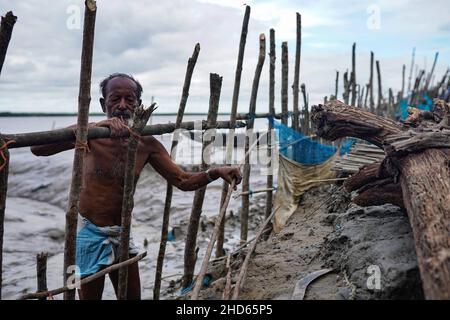 Mongla, Bangladesch. 12th September 2021. Ein alter Mann sah, wie er den Zaun wieder einstellte, um das von Flut durchbrach Embargo im Küstengebiet des Dorfes Jaymani zu schützen.Bangladesch ist eines der Länder, die am stärksten von den Auswirkungen des Klimawandels betroffen sind. Die regelmäßigen und schweren Naturgefahren, die Bangladesch bereits unter tropischen Wirbelstürmen, Hochwasser, Flußerosion, Überschwemmungen, Erdrutschen und Dürren leidet, werden durch den Klimawandel immer intensiver und häufiger werden. (Foto von Sultan Mahmud Mukut/SOPA Image/Sipa USA) Quelle: SIPA USA/Alamy Live News Stockfoto