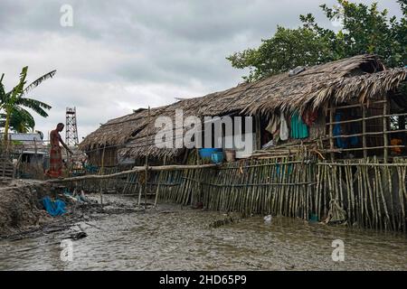 Mongla, Bangladesch. 12th September 2021. Ein Mann geht auf einer Baumstamm-Brücke, die eingerichtet ist, um sich während der Flut an der Küste des Dorfes Jaymani leicht zu bewegen.Bangladesch ist eines der Länder, die am stärksten von den Auswirkungen des Klimawandels betroffen sind. Die regelmäßigen und schweren Naturgefahren, die Bangladesch bereits unter tropischen Wirbelstürmen, Hochwasser, Flußerosion, Überschwemmungen, Erdrutschen und Dürren leidet, werden durch den Klimawandel immer intensiver und häufiger werden. (Foto von Sultan Mahmud Mukut/SOPA Image/Sipa USA) Quelle: SIPA USA/Alamy Live News Stockfoto