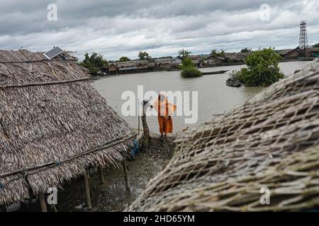 Mongla, Bangladesch. 12th September 2021. Eine Frau steht vor ihrem Haus, das aufgrund eines Wirbelsturms im Küstengebiet des Dorfes Jaymani mehrmals wiederaufgebaut wird.Bangladesch ist eines der Länder, das am stärksten von den Auswirkungen des Klimawandels betroffen ist. Die regelmäßigen und schweren Naturgefahren, die Bangladesch bereits unter tropischen Wirbelstürmen, Hochwasser, Flußerosion, Überschwemmungen, Erdrutschen und Dürren leidet, werden durch den Klimawandel immer intensiver und häufiger werden. (Bild: © Sultan Mahmud Mukut/SOPA-Bilder über ZUMA Press Wire) Stockfoto