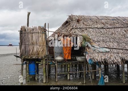 Mongla, Bangladesch. 12th September 2021. Eine Frau steht vor ihrem Haus, das aufgrund eines Wirbelsturms im Küstengebiet des Dorfes Jaymani mehrmals wiederaufgebaut wird.Bangladesch ist eines der Länder, das am stärksten von den Auswirkungen des Klimawandels betroffen ist. Die regelmäßigen und schweren Naturgefahren, die Bangladesch bereits unter tropischen Wirbelstürmen, Hochwasser, Flußerosion, Überschwemmungen, Erdrutschen und Dürren leidet, werden durch den Klimawandel immer intensiver und häufiger werden. (Bild: © Sultan Mahmud Mukut/SOPA-Bilder über ZUMA Press Wire) Stockfoto