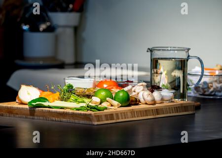 Zutaten von TomYamKung (Shrimp Spicy Thai Soup) ist eine Zitrone, Garnelen, Chili, Zitronengras, Zwiebeln, Tomaten, Pilze und Würzsoße in der Küche Stockfoto