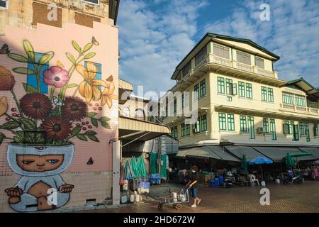 Szene entlang der Ong Ang Walking Street entlang des Klong (Kanal) Ong Ang in Phahurat/Chinatown in Bangkok, Thailand; links: Ein Wandbild des thailändischen Künstlers Alex Face Stockfoto