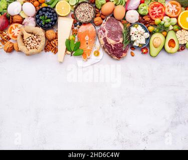 Ketogene Low Carbs Diät-Konzept. Zutaten für die Auswahl gesunder Lebensmittel auf weißem Beton eingerichtet. Stockfoto