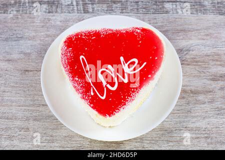 Kuchen in Herzform auf Holzhintergrund. Valentinstag-Konzept. Stockfoto