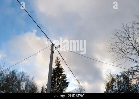 Betonmast und Drähte gegen den Himmel, Winterszene Stockfoto