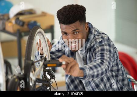 Junger männlicher Mechaniker, der am Fahrrad arbeitet Stockfoto