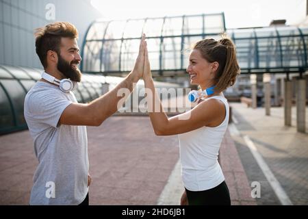 Glückliches Läuferpaar, das im Rahmen eines gesunden Lebensstils draußen trainiert. Menschen Sport Laufkonzept Stockfoto