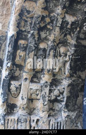 Nahaufnahme von altertümlichen verwitterten Schnitzereien von Figuren, Gesichtern und Blumen in der St. Thomas the Martyr Church, Upholland, Lancashire, Großbritannien Stockfoto