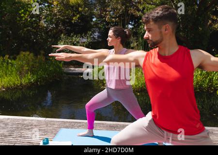 Junger Mann und Frau trainieren gemeinsam im Park an sonnigen Tagen Stockfoto