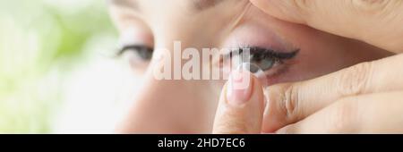 Junge Frau legt weiche Kontaktlinsen auf Augenhöhe Stockfoto