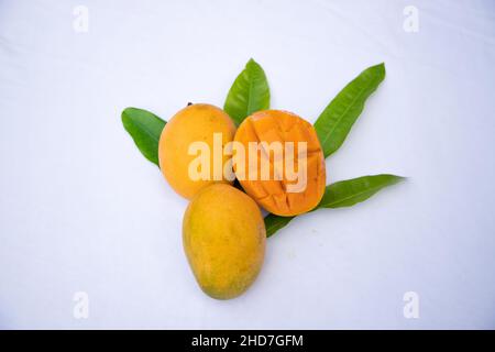 Frische köstliche Slice Gelb reifen Mango mit grünem Blatt auf isoliertem Hintergrund Stockfoto