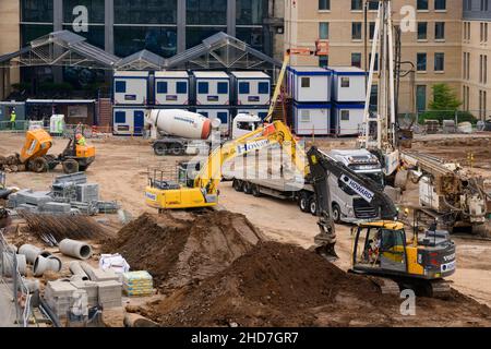 Vielbeschäftigte Baustelle (Baustoffe, verschiedene Fahrzeuge, Bagger Erdbeweger, Zementmischer) - Hudson Quarter, North Yorkshire England Großbritannien. Stockfoto