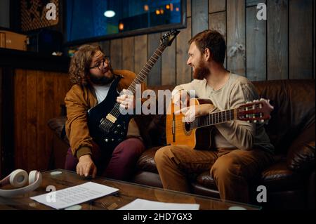 Instruktor, der Mann unterrichtet, spielt zu Hause Gitarre Stockfoto